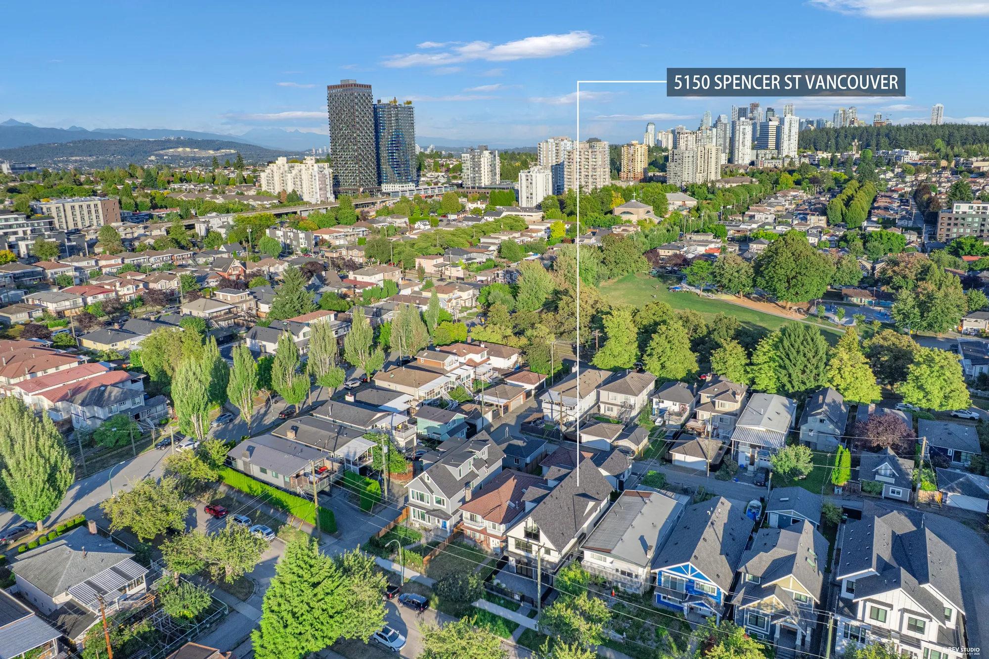 Aerial over the neighbourhood toward the towers, the property marked