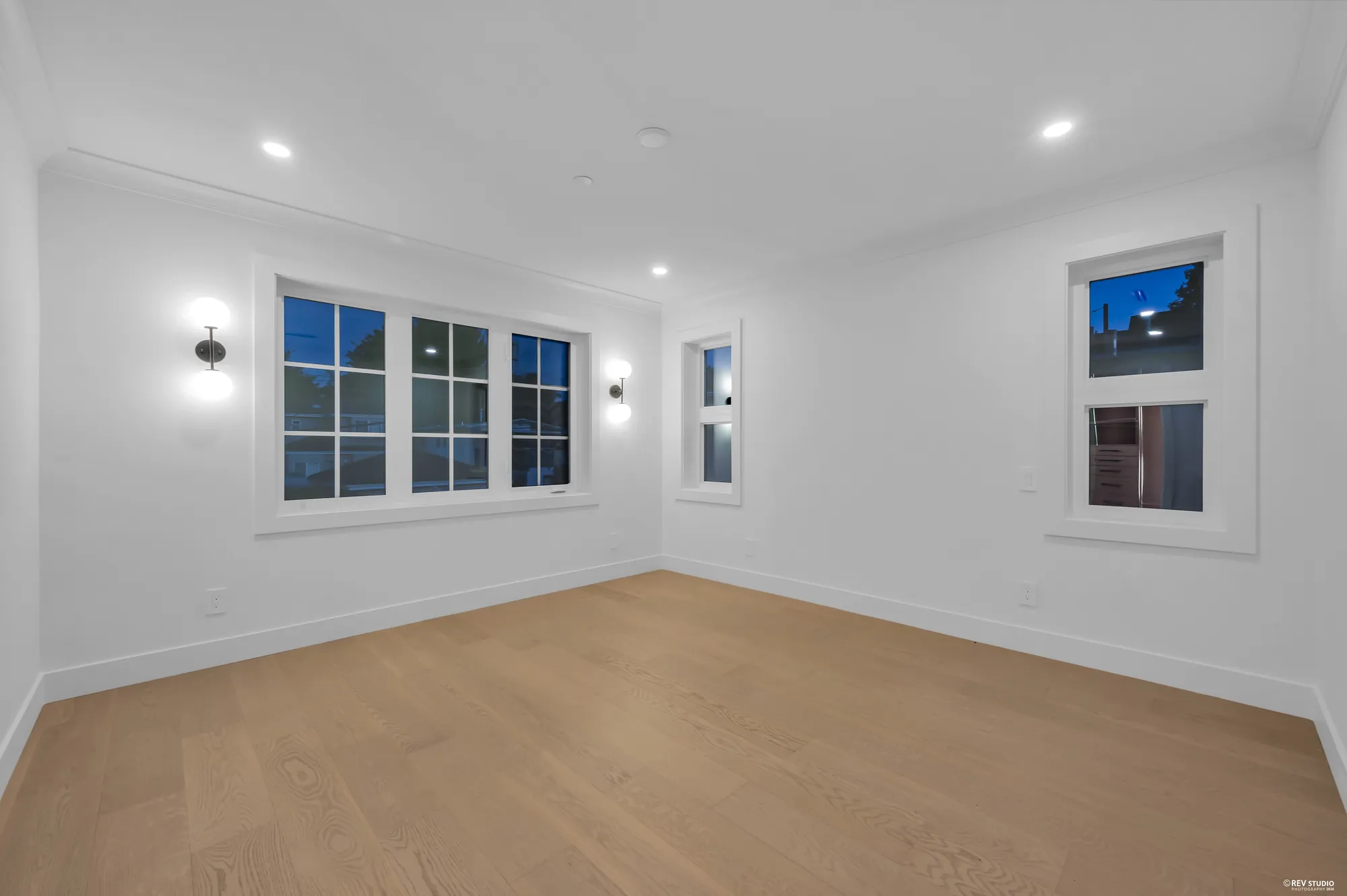 Bedroom with windows on two walls and wall sconces