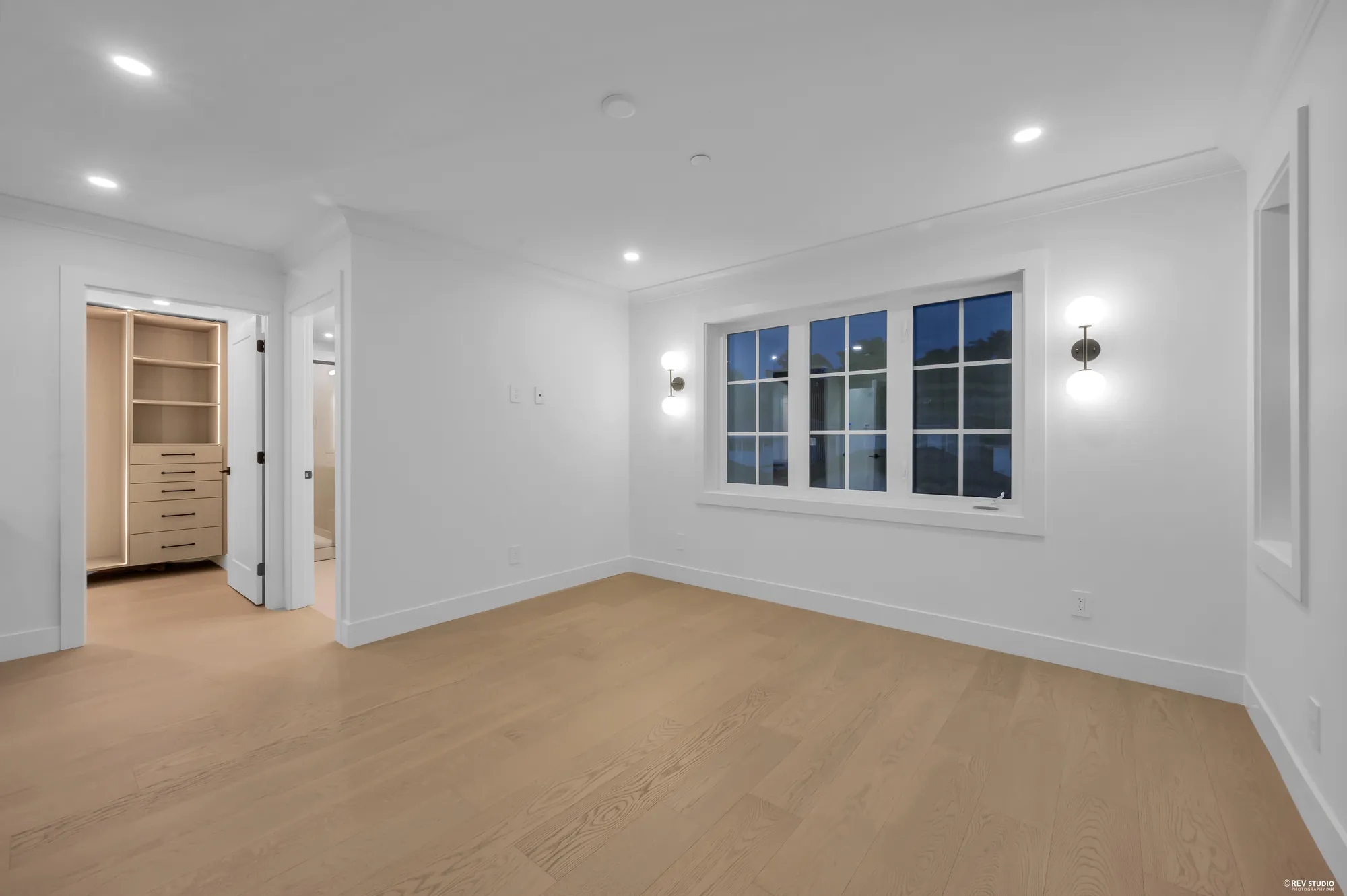 The same bedroom from the doorway, with a window to the side