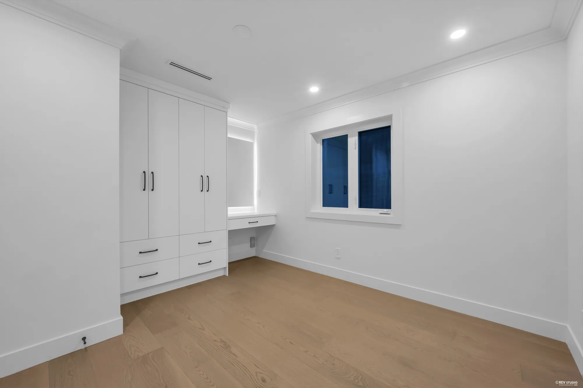 The same room showing its wall of built-in wardrobes