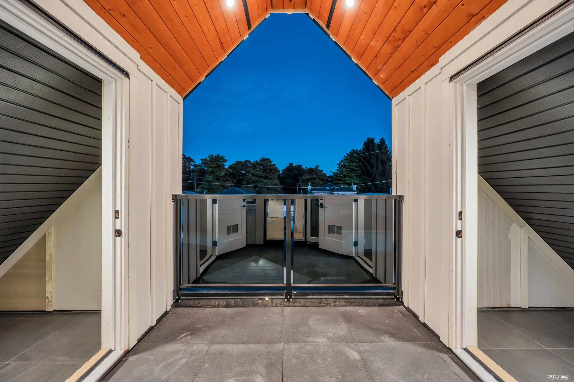 Looking through the covered walk under a cedar soffit at dusk