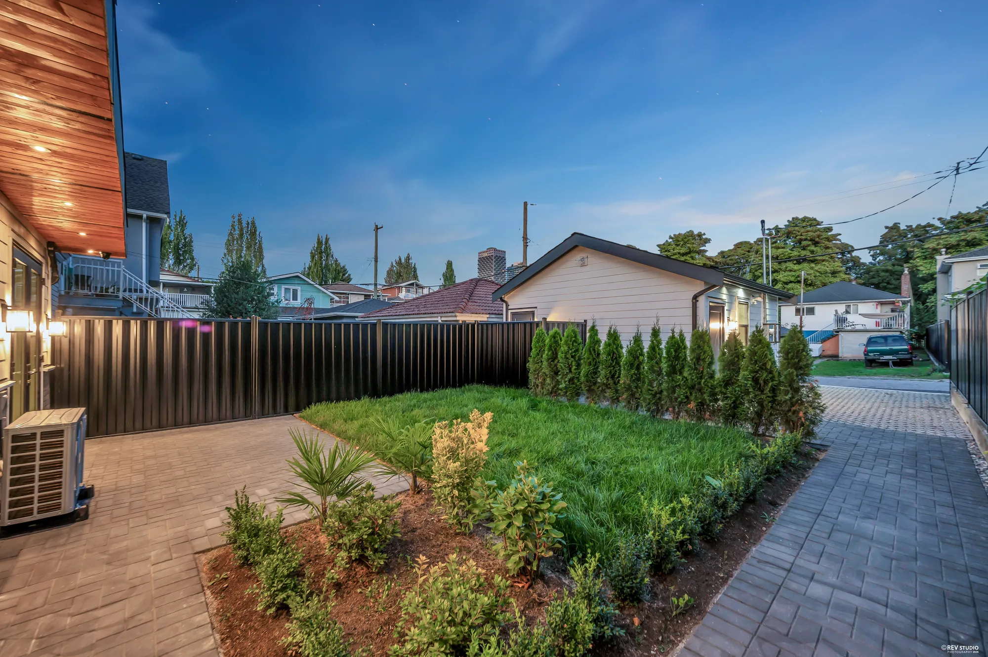 The fenced garden with a lawn, new hedging and the heat pump to one side