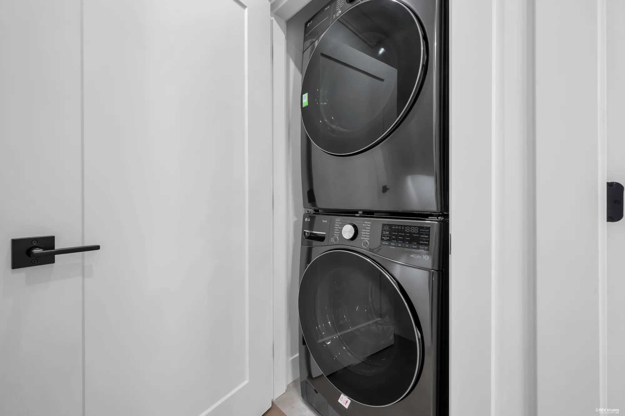 Stacked washer and dryer in a cupboard off the hall