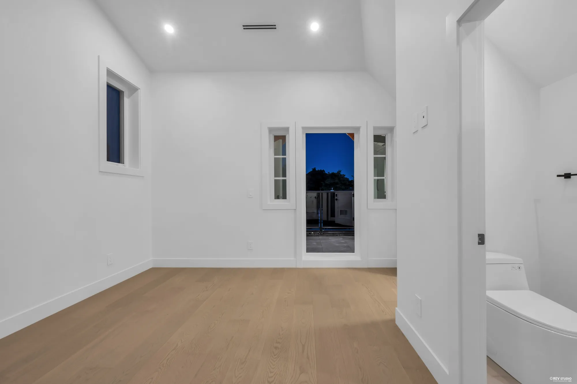 The top-floor room with a sloped ceiling and a window at the end